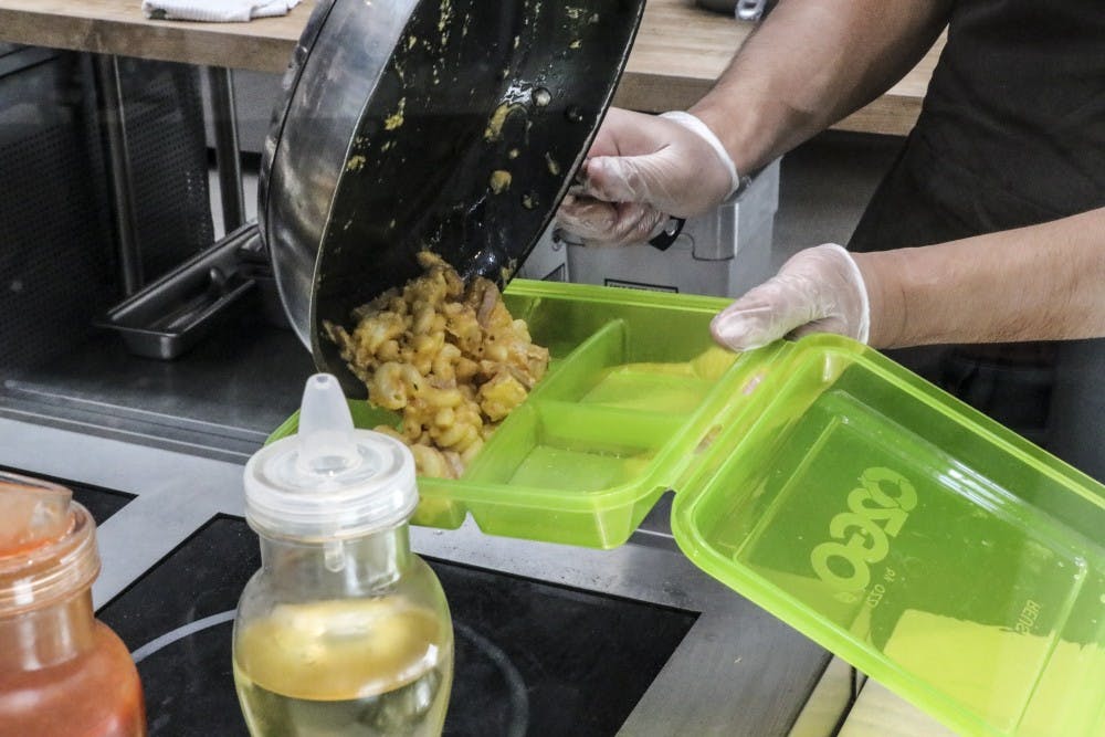 A La Posada cook fills one of the new LaPo To-Go boxes with Mac & Cheese on Aug. 26, 2018.