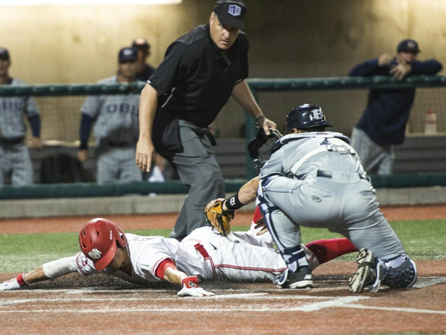 Senior infielder Dalton Bowers slides into home base as a Dallas Baptist catcher tries to tag him out Friday night at Santa Ana Star Field. The Lobos lost to Dallas Baptist 5-2 in their first of three games. 