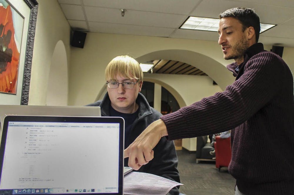 Senior advisor for Anderson School of Management Andres Rigg, right, helps freshman and business major Trent Ballowe register for Spring semester classes on Nov. 27,2017 at the Operation Registration event.