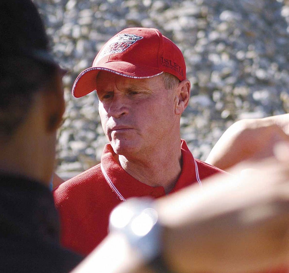 Head track and field coach Matt Henry talks to his runners before a practice at the UNM Track and Field Stadium on Wednesday. Coaches Matt and Mark Henry announced their retirement on Monday. 
