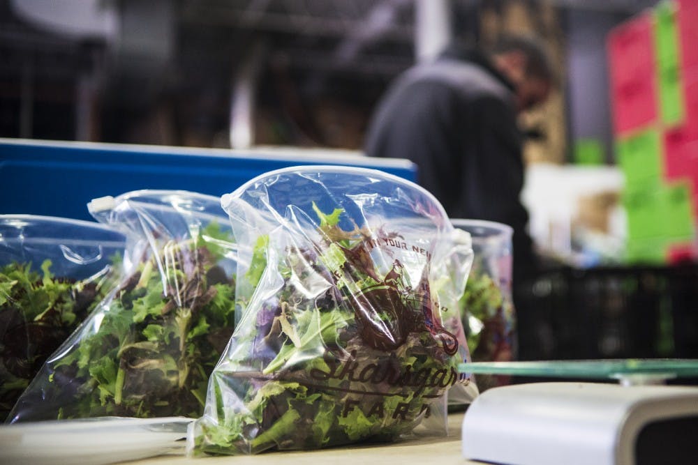 Skarsgard warehouse workers fill bags with lettuce Sunday morning. On Sundays, an average of 400 orders are packaged and sent out to Skarsgard Farm customers.