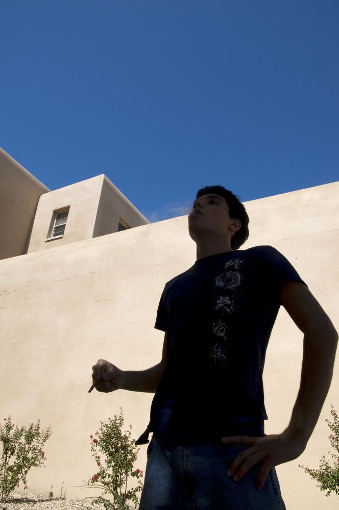 	Luke Waruszewski smokes outside Northrop Hall at the designated smoking area on Tuesday. The hall is said to have negative air pressure, which sucks in the secondhand smoke. 
