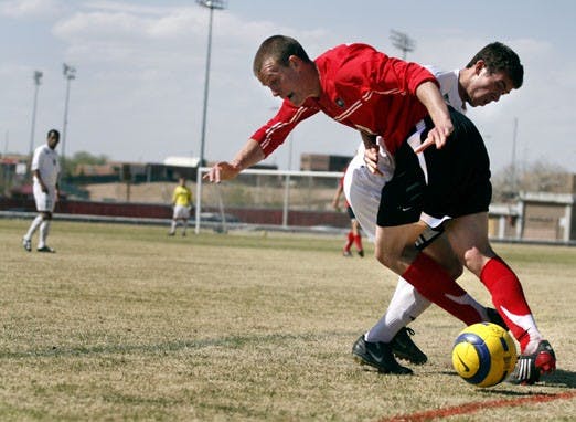 Lobo midfielder Michael Reed dribbles the ball away from Fort Lewis defender Keane Hamilton on Saturday at Robertson Field. UNM defeated Fort Lewis 2-0 and Air Force 3-0 in Saturday's spring exhibition games.