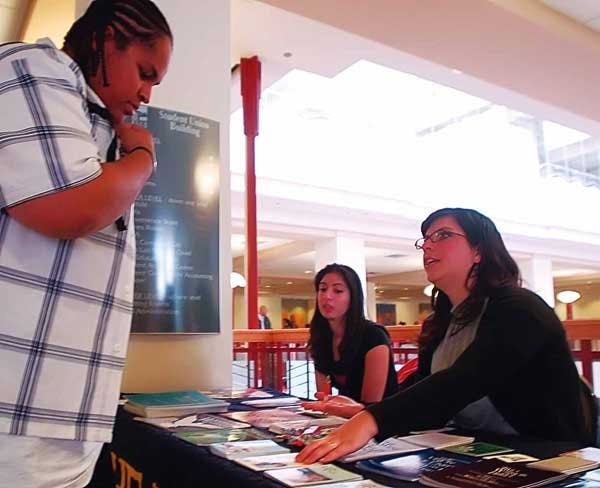 Aniseh Bro, right, and Mona Talebreza talk to Romulous Charles at a Bahai Student Association booth at the SUB on Wednesday. 