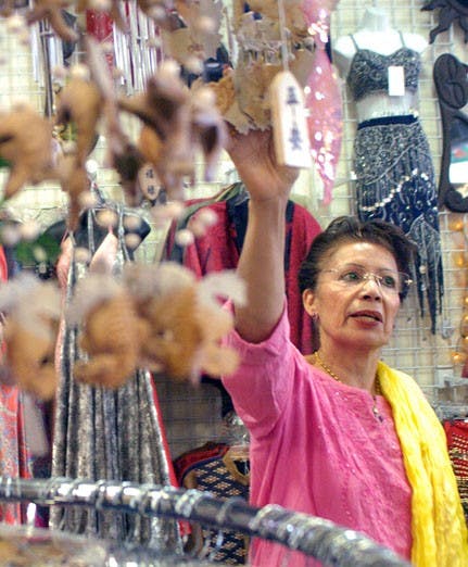 Rajnee Huber, co-owner of Earth Treasures Us, looks at wind chimes in the store Sunday. 