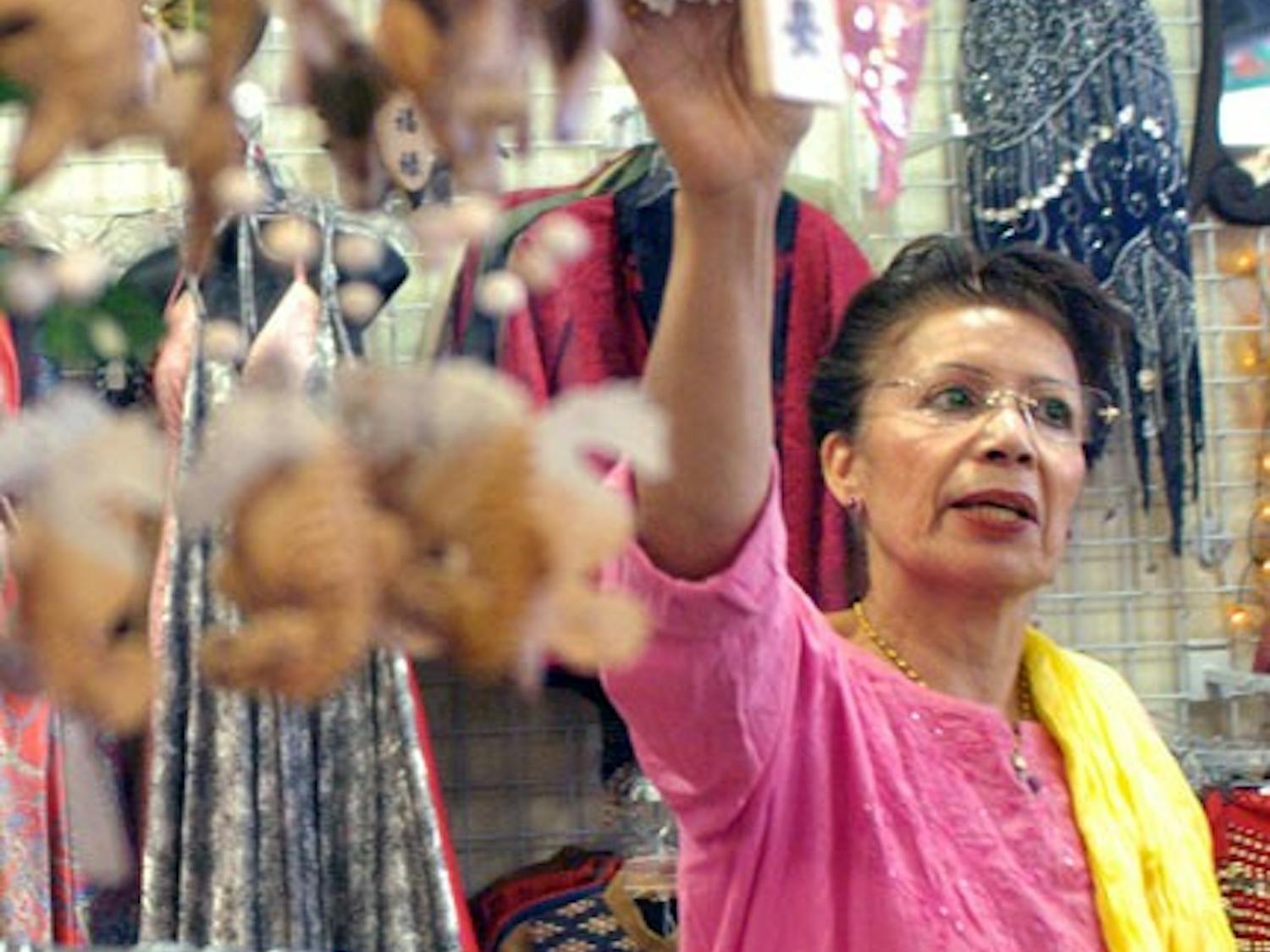 Rajnee Huber, co-owner of Earth Treasures Us, looks at wind chimes in the store Sunday.