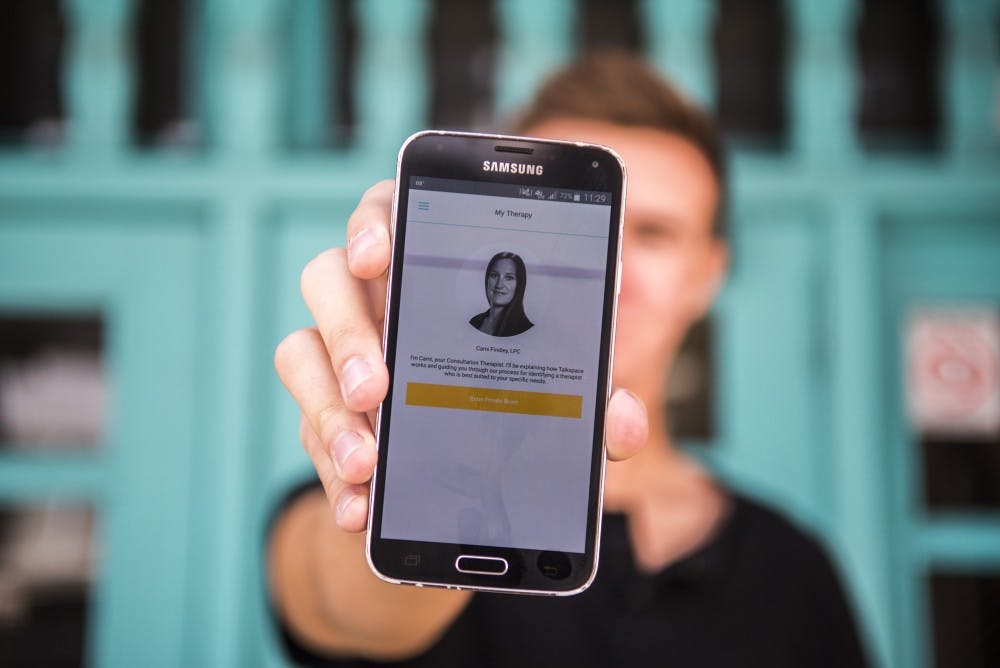 Jared Price holds up the home screen to a therapy app called Talkspace which allows users to communicate with therapists. Price is a member of the fraternity Alpha Tau Omega which partnered up with Talkspace to provide its members with a free trial period.&nbsp;