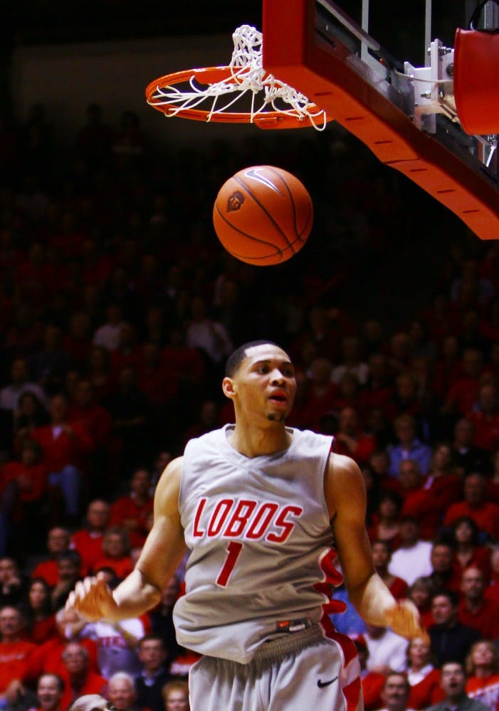 	Darington Hobson descends after absorbing a foul and converting a difficult shot Wednesday at The Pit. Hobson’s 20 points, 10 rebounds and 6 assists lead the Lobos to an 83-61 victory over Wyoming.