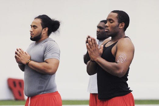 UNM football players Jaymar Latchison, left, and Josh Taufalele meditate during one of the Lobos' yoga classes at the Indoor Practice Facility on July 22.