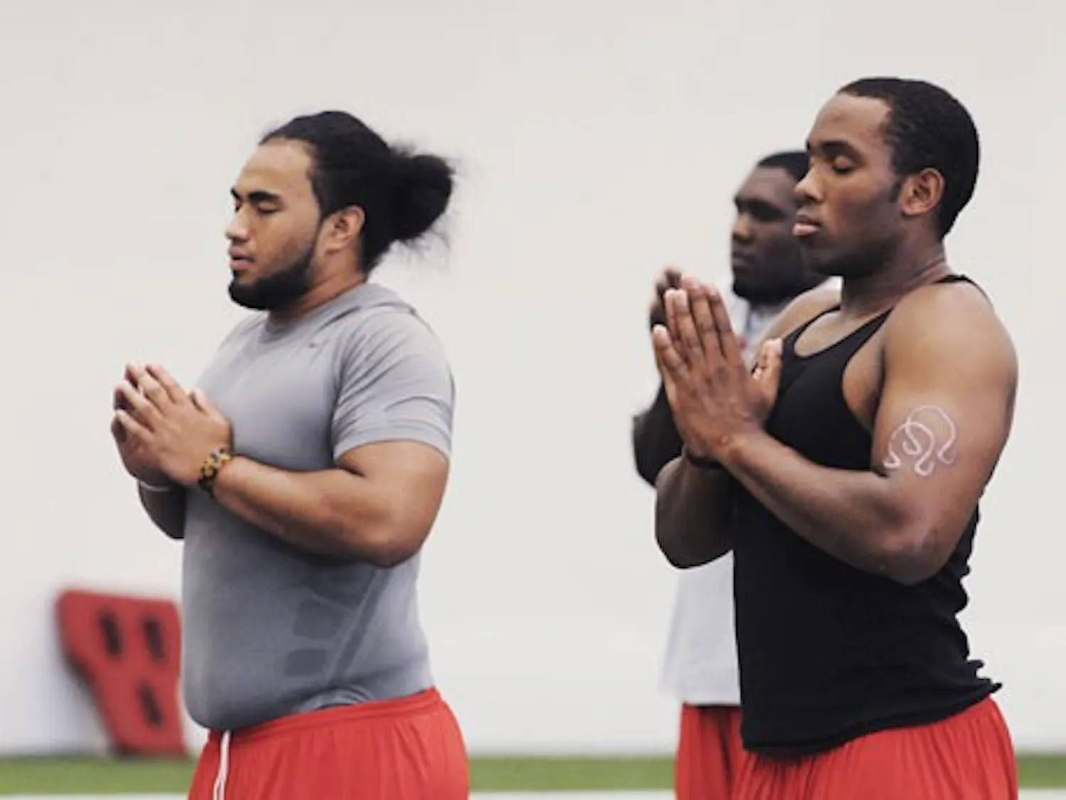 UNM football players Jaymar Latchison, left, and Josh Taufalele meditate during one of the Lobos' yoga classes at the Indoor Practice Facility on July 22.