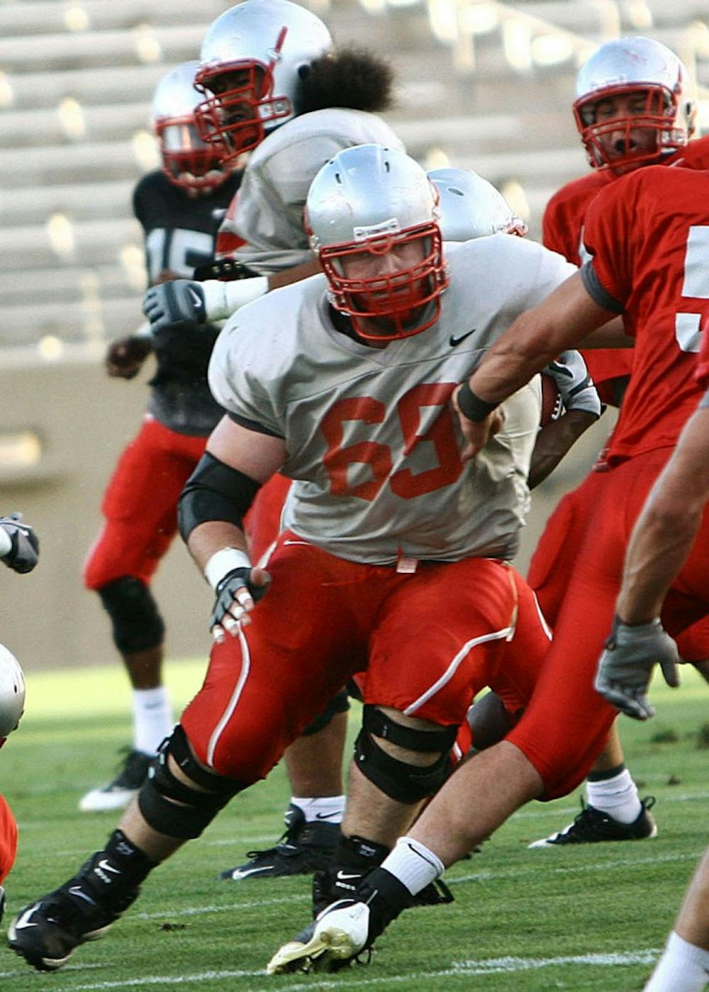 	Lobo center Erik Cook blocks one of his UNM teammates during the Cherry Silver scrimmage in this file photo. Cook said playing against former head coach Rocky Long, who is now San Diego State’s defensive coordinator, will be peculiar.