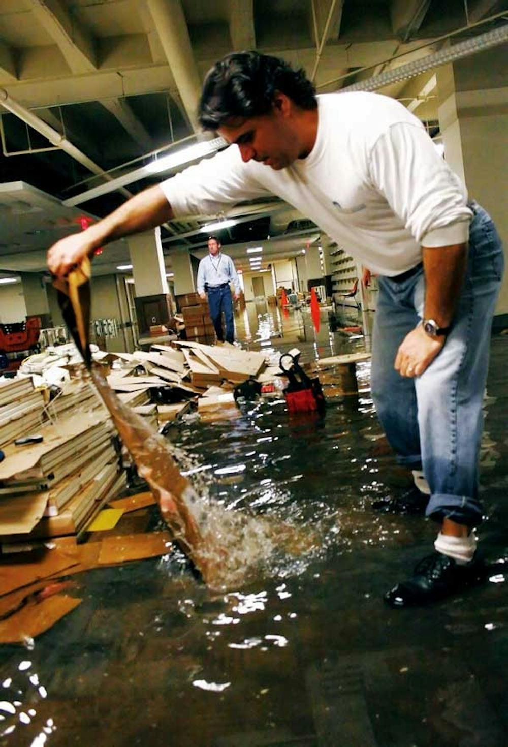 Rick Henrard, project manager for the Zimmerman Library basement's renovation, examines flood damages caused by a burst pipe Wednesday. 