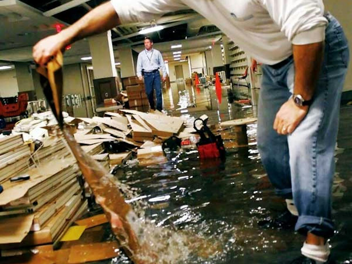 Rick Henrard, project manager for the Zimmerman Library basement's renovation, examines flood damages caused by a burst pipe Wednesday.