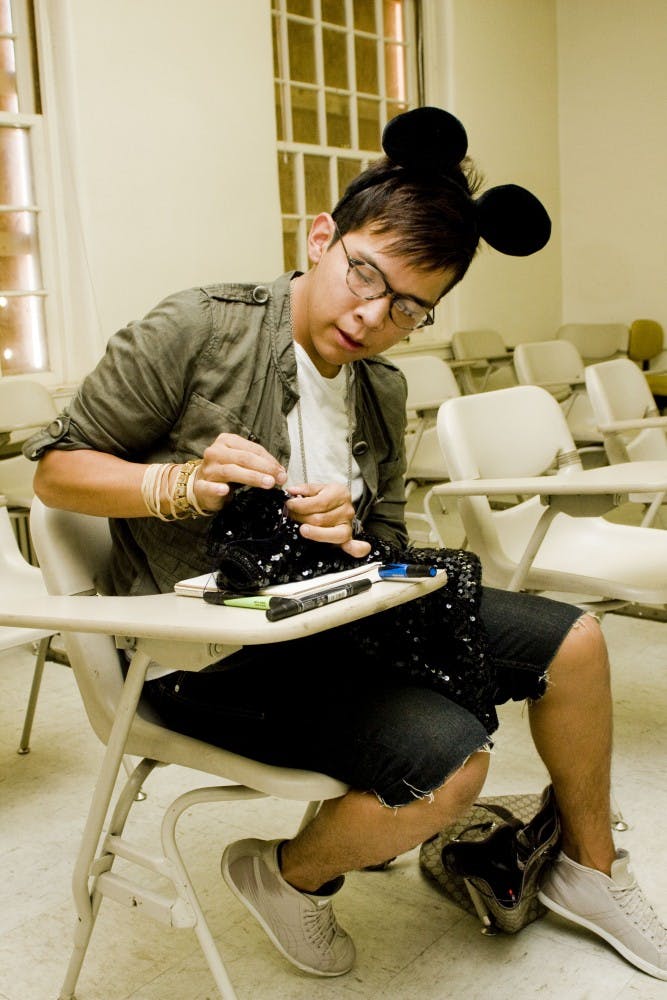 	Darnell Daniels tailors a 1980s black-sequined cardigan he found at a thrift shop. He said he hopes the sweater will become a wearable vest, using the leftover cloth of the sleeves to lengthen the hem. 