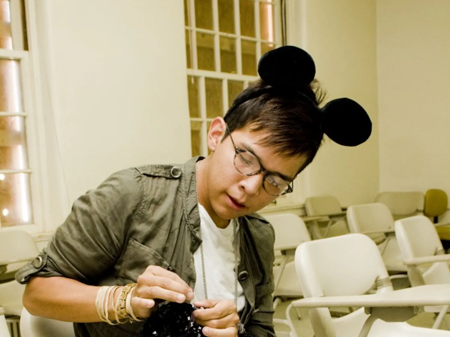 Darnell Daniels tailors a 1980s black-sequined cardigan he found at a thrift shop. He said he hopes the sweater will become a wearable vest, using the leftover cloth of the sleeves to lengthen the hem.