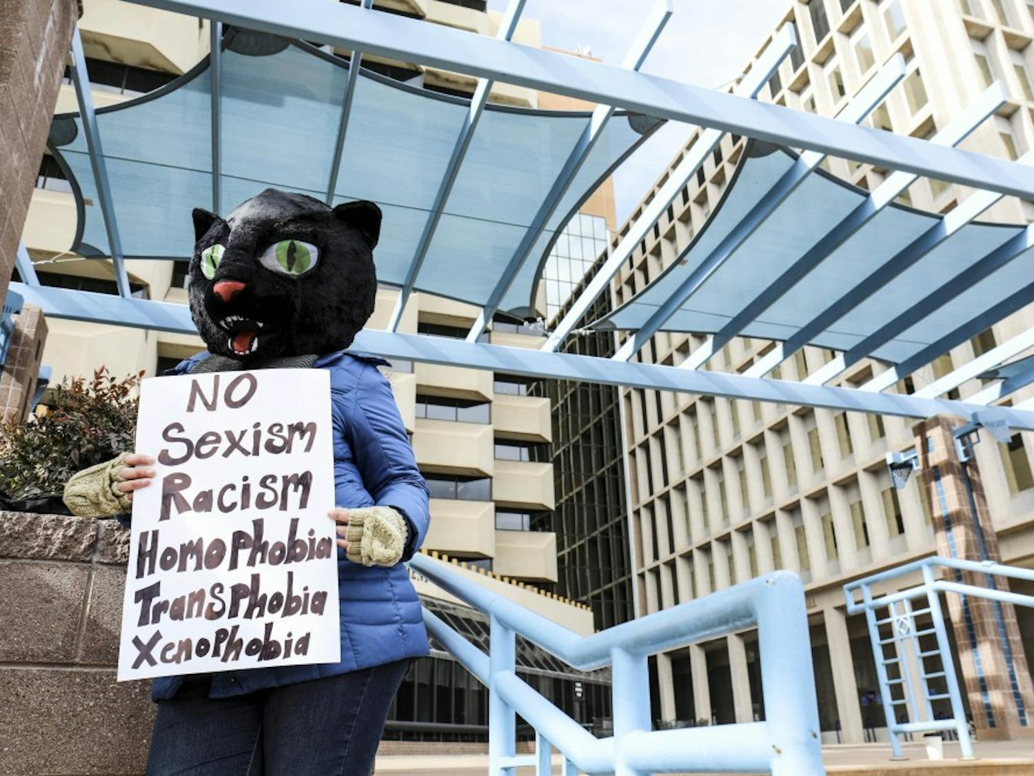 A woman?s rights supporter holds a sign while wearing a cat costume during the women?s march at the Civic Plaza. Hundreds of women, children and men attended the event in support of gender rights and other causes.
