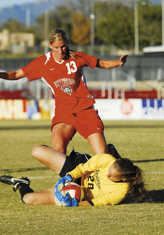 UNM forward Kristine Sweat stops before running over BYU goalie Erika Woodbury after a shot on goal during a tied game Saturday at the UNM Soccer Complex.  