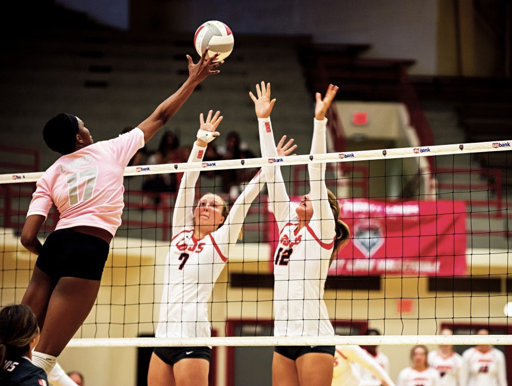 UNM Alumni Skye Gullat (17) attempts a dink over UNM players  Victoria Spragg (70 and Cassie House (12) on Saturday, August 20th at the Johnson Center.