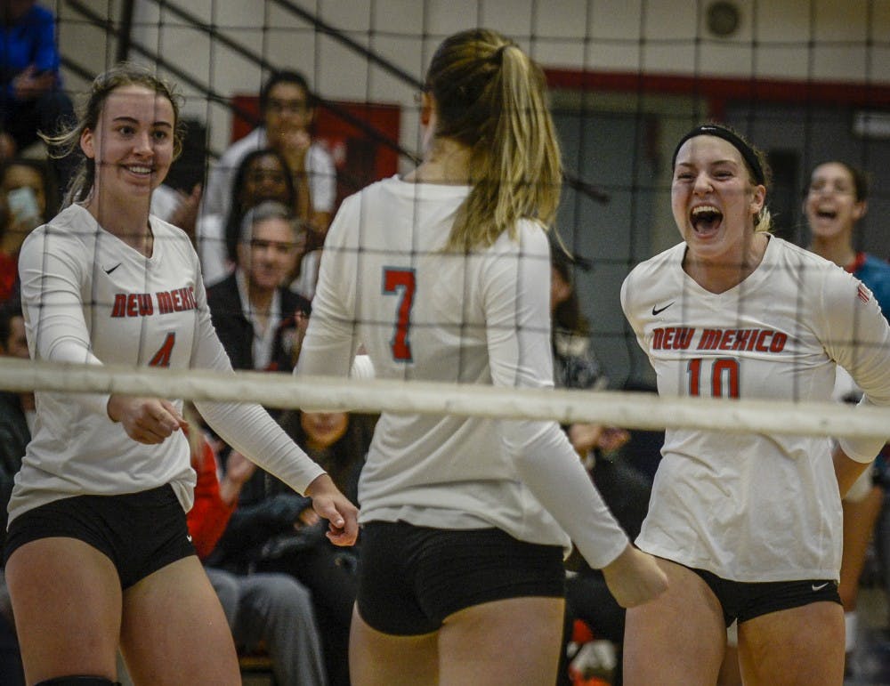 Lauren Twitty &nbsp;#10, and Carson Heilborn &nbsp;#4, celebrate with Victoria Spragg &nbsp;#7, after Spragg scores against Utah State in Johnson Center September 30, 2017. The Lobos swept the Aggies, 3-0 on Saturday afternoon.
