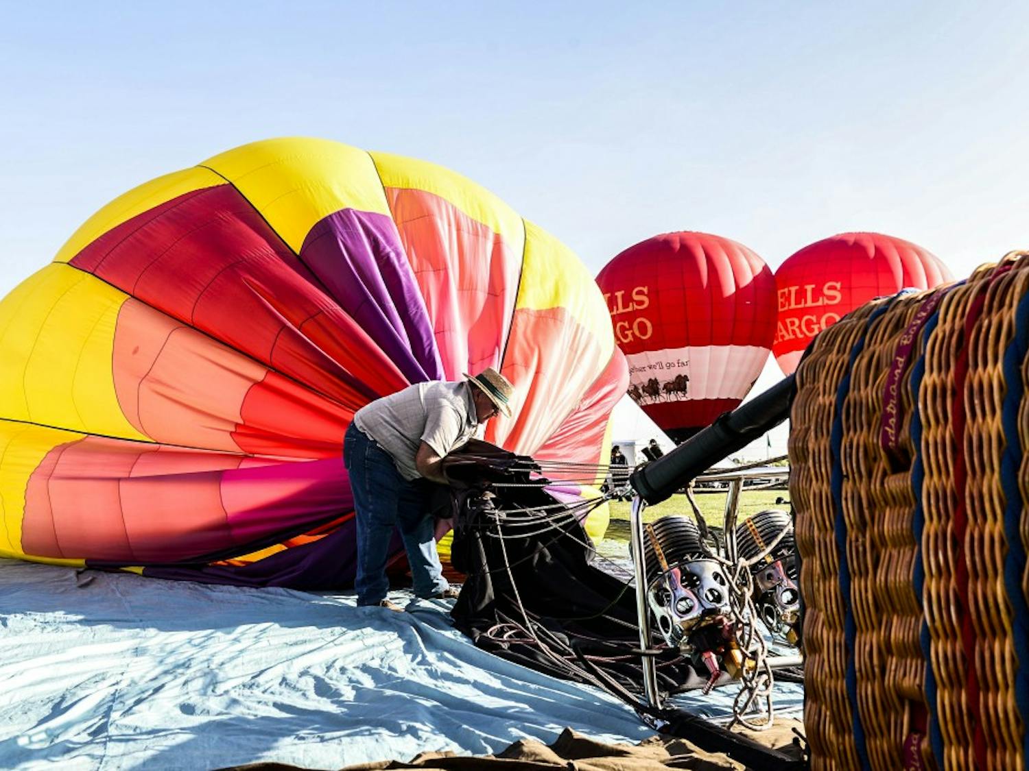 After gusty winds and unexpectedly warm air on Oct. 9, 2017 at the Albuquerque International Balloon Fiesta, one hot air balloon team decides to head home for the morning, deflating and folding their balloon. 
