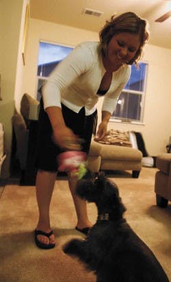 Monique Fellows, a senior at UNM graduating in December, plays with her dog Beau in her West Side home Thursday night. Fellows was in New Orleans during Hurricane Katrina.