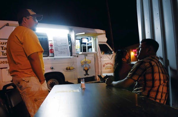 El Taco Loco owner Floriberto Mancilla, right, talks to Cesar Guevara while he waits for his order at 6101 Central Ave. N.E. on Wednesday.