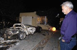 Lawrence Martinez looks at his charred 1998 Chevrolet Corvette on Saturday near Lomas and Carlisle boulevards. It was one of 10 to 12 vehicles near UNM that caught fire Friday morning, Albuquerque Fire Department spokesman Patrick Baca said.