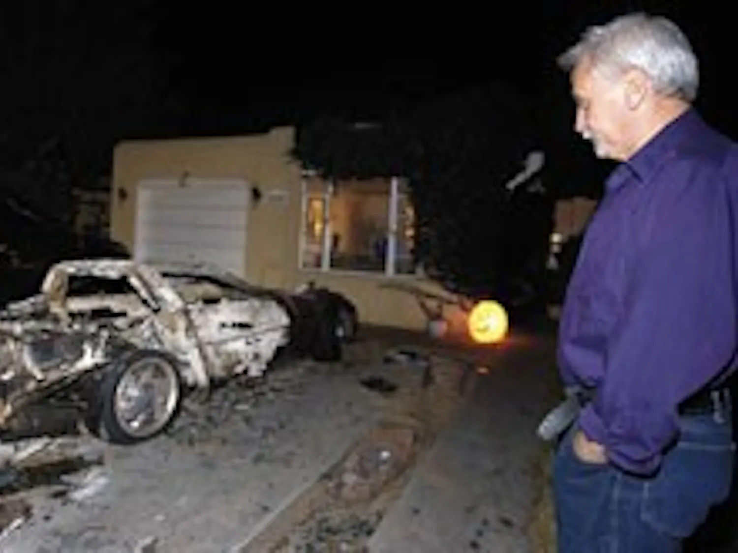 Lawrence Martinez looks at his charred 1998 Chevrolet Corvette on Saturday near Lomas and Carlisle boulevards. It was one of 10 to 12 vehicles near UNM that caught fire Friday morning, Albuquerque Fire Department spokesman Patrick Baca said.