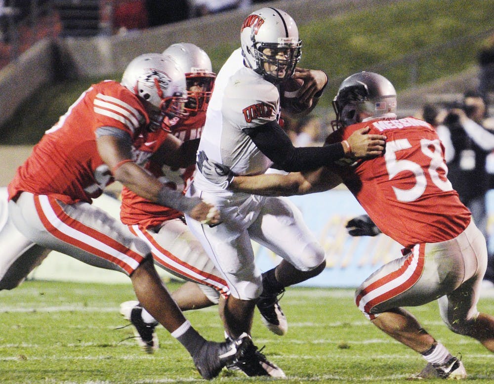 	UNLV backup quarterback Mike Clausen is hauled down by linebacker Carmen Messina and a group of Lobo gang-tackling defenders. Messina had 17 tackles and a sack, but the Lobos couldn’t overcome a late punt-return fumble and fell to 0-7 overall.