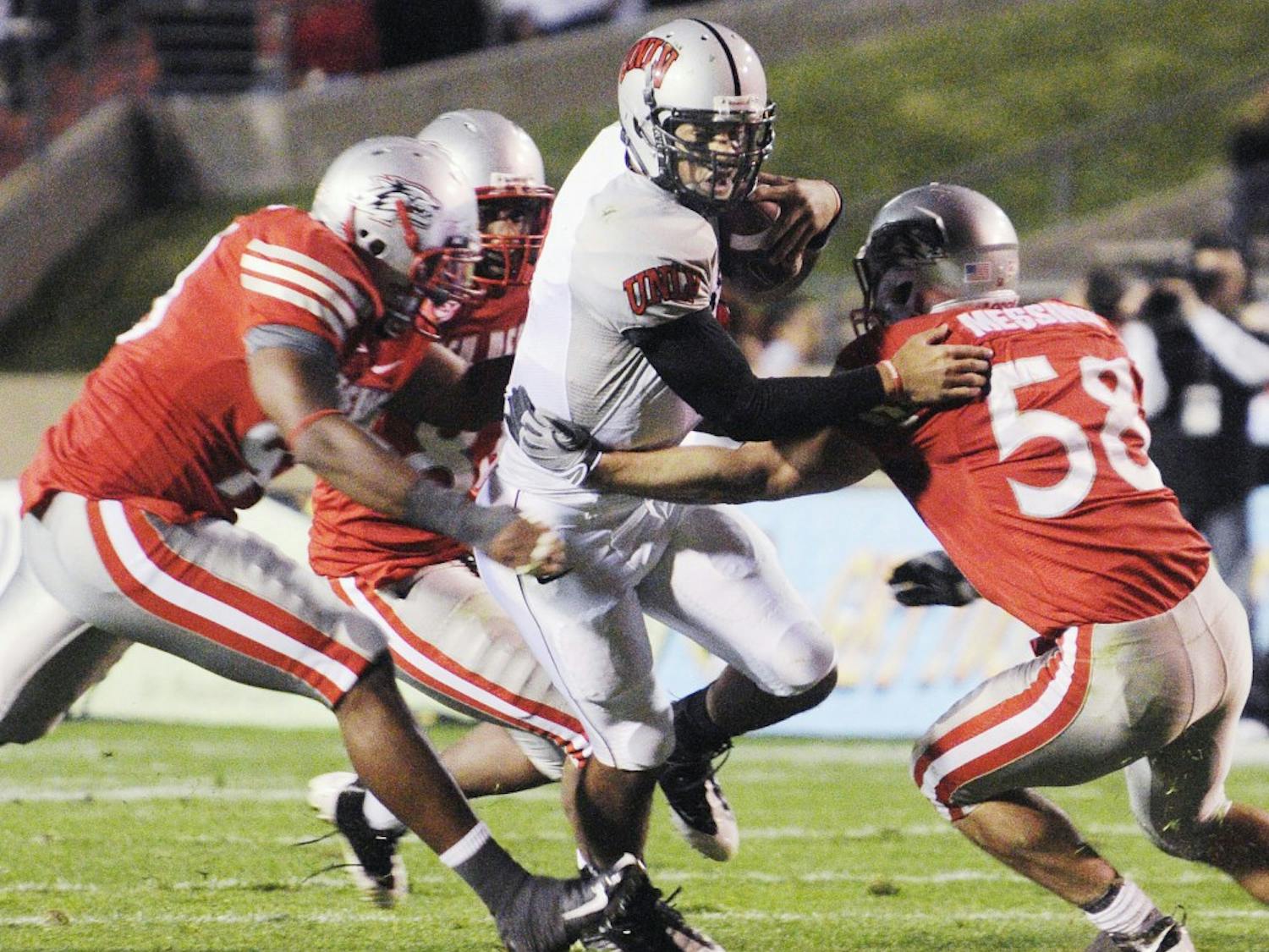 UNLV backup quarterback Mike Clausen is hauled down by linebacker Carmen Messina and a group of Lobo gang-tackling defenders. Messina had 17 tackles and a sack, but the Lobos couldn’t overcome a late punt-return fumble and fell to 0-7 overall.