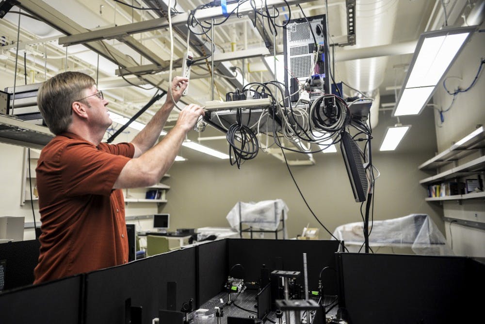 The Department of Chemistry and Chemical Biology's Jeff Rack prepares to turn on a red working light to demonstrate how to operate&nbsp;a rig comprised of lasers on&nbsp;Tuesday August 16, 2016, at Clark Hall. Rack uses this device to observe how molecules interact with different polymers.&nbsp;