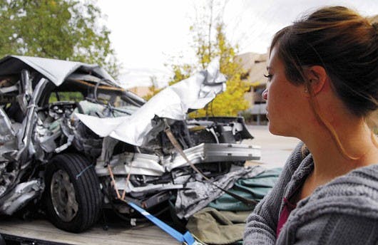 Micki Lucero looks at a wrecked Cadillac that belonged to a Nebraska couple that were killed driving on I-40 by drunken driver Lloyd Larson, a Bureau of Indian Affairs employee, on Jan. 25, 2002. The car was put on display during Red Ribbon Day to promote