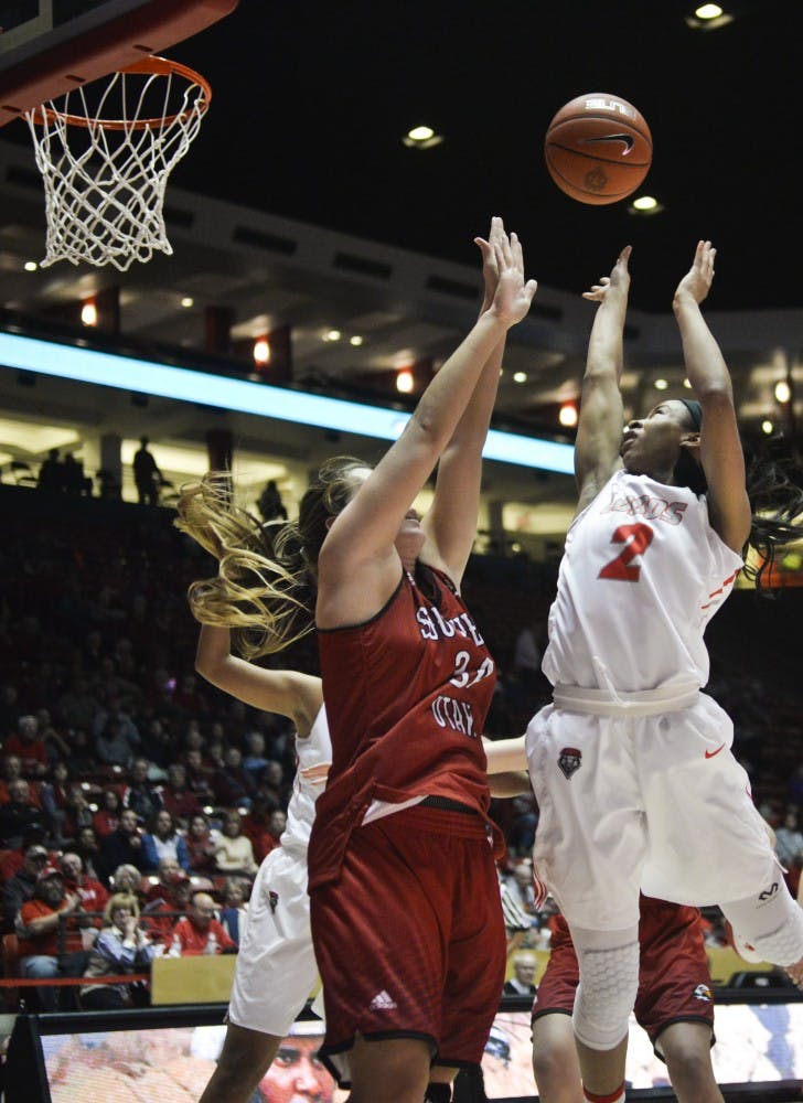 Sophomore guard Kenya Pye reaches past a Southern Utah player for a close range jump shot at WisePies Arena Friday night. The Lobos beat Southern Utah 70-48.&nbsp;
