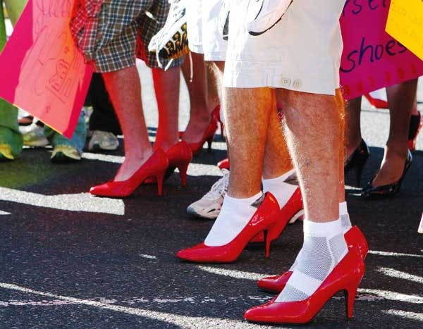 Men in high heels gather for Walk a Mile in Her Shoes. Participants walked across campus to raise awareness of violence against women.