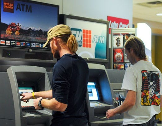 Ian Latella, left, withdraws money at a Wells Fargo ATM in the SUB on Oct. 9.  