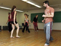 Producing director Chad Brummet, right, leads the performers in warmups in the basement of Popejoy hall.