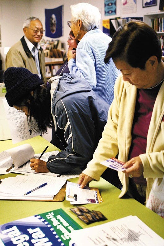 Bob Watada, left, speaks with an audience member at the Albuquerque Center for Peace and Justice on Friday. Watada and his wife, Rosa Sakanishi, right, are on a 16-state tour to raise support for their son, Ehren Watada, who is the first commissioned offi