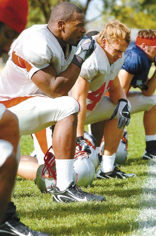 UNM football player Quincy Black takes a break on the sideline during Tuesday's practice at the Lobo football practice field.