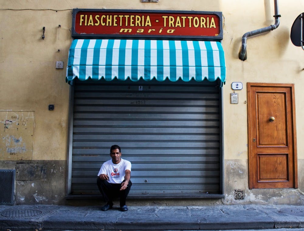 	A man smokes a cigarette during siesta in Florence.