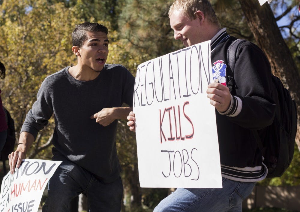 Tre Graves (left) and Ryan Boyle debate at a rally held at Smith Plaza Thursday afternoon. The rally focused on free college tuition for public universities.&nbsp;