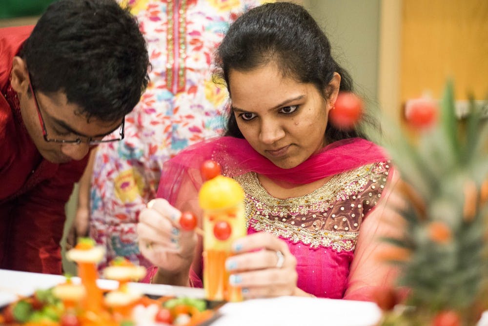 Geetha Yedida works on a fruit sculpture during the International Cook-off event at the SUB. The cooking competition was put on by the Global Education Office with teams comprised of international students from Bangladesh, China, the Czech Republic, India, Iran, and Japan.