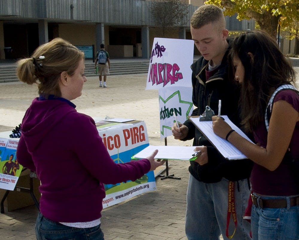 	UNM-PIRG Field Organizer Leandra Cole, guides students Erika Avila, right, and Oliver Stephanz to sign a petition on Nov. 4. The organization is asking for $80,000 of student fees to hire full-time PIRG employees.