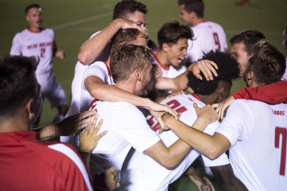 Omar Grey (center) is surrounded by his teammates while celebrating his first goal at UNM against Seattle University on Aug. 24, 2018. Grey, who is originally from Seattle, decided between the two schools in the recruiting process.&nbsp;&nbsp;