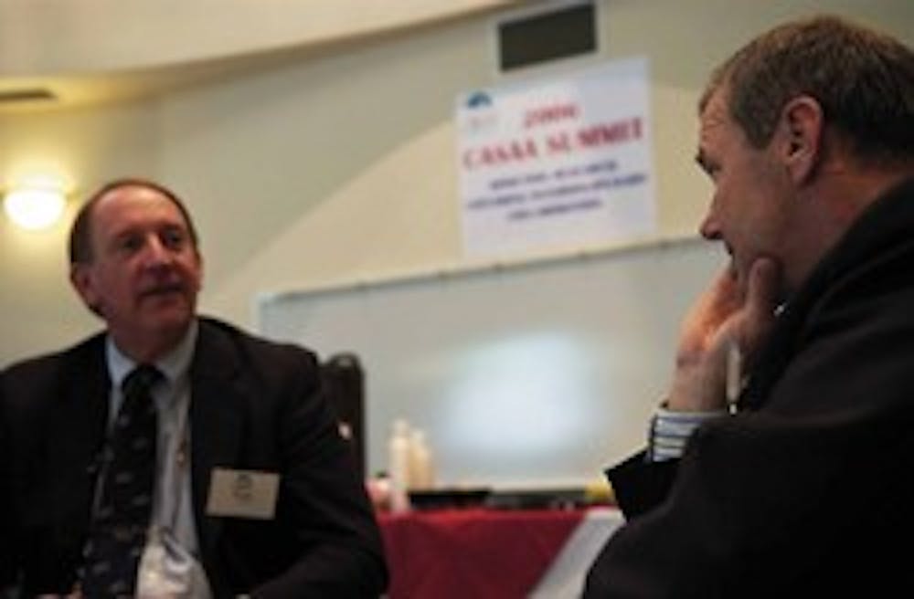 Former CASAA director Philip May, left, talks with acting director Michael Dougher at the end of the first day of a two-day summit for research on addiction at UNM held at the Science and Technology Park on Tuesday.  