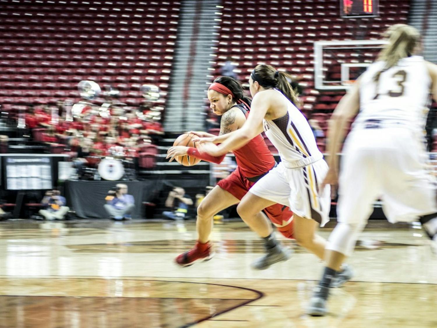 Cherise Beynon drives past Taylor Rusk during the second half of Tuesday night's game against Wyoming at Thomas & Mack Arena in Las Vegas, Nevada. The Lobos lost 66-69.