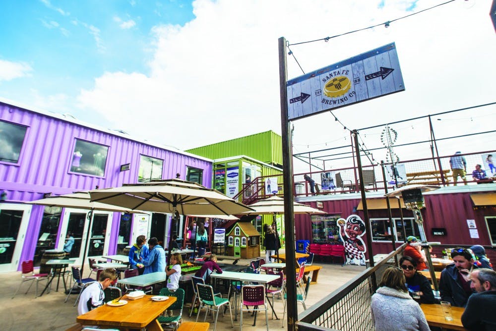 People sit outside on patios Sunday afternoon at Green Jeans Farmery. Green Jeans is a project that opened in early 2015 which consists of a complex of shipping containers that house a brewery and various restaurants.