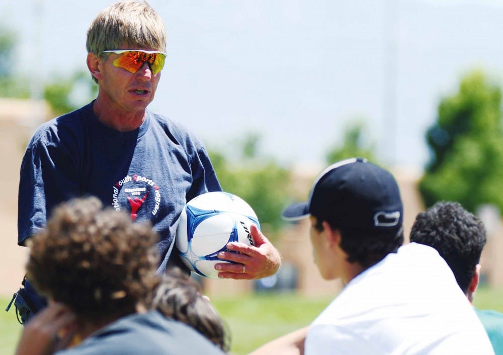 Coach Andy Murray talks to youth soccer players before doing drills June 8 on Johnson Field. They are participating in the National Youth Sports Program, which has been running for the past 36 years.