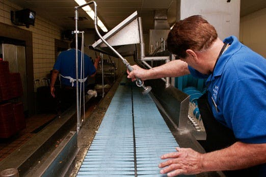 Juan Martinez cleans up the tray-washing station in La Posada on Monday. La Posada has started a program called Trayless Mondays to reduce waste.