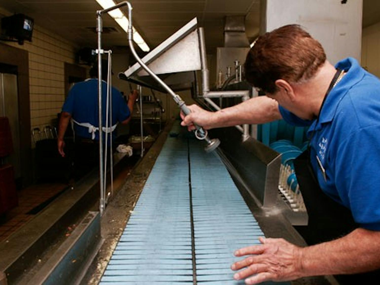 Juan Martinez cleans up the tray-washing station in La Posada on Monday. La Posada has started a program called Trayless Mondays to reduce waste.