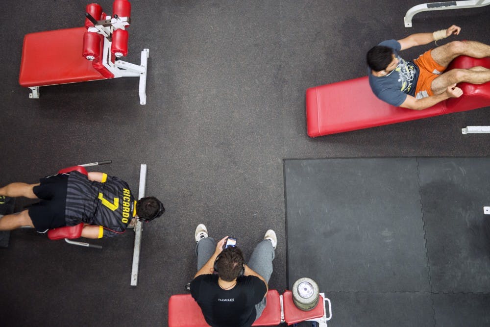 UNM students exercise at the bottom level of the Johnson Center’s weight room during Friday night’s open hours. The multilevel weight room carries some equipment but during busy times during the week students have trouble finding open spaces.